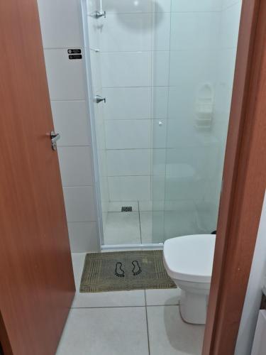 uma casa de banho com um chuveiro, um WC e um tapete em Estúdio Mobiliado Condomínio da Fé Canção Nova apto 02 em Cachoeira Paulista