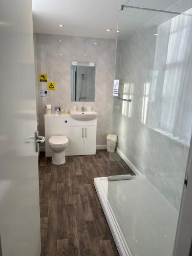 La salle de bains est pourvue de toilettes, d'un lavabo et d'une douche. dans l'établissement Clifton Hotel, à Scarborough