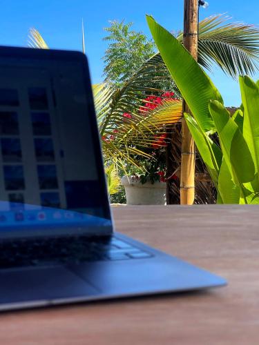 a laptop computer sitting on top of a wooden table at casaNorte paraíso norteño mirador de Ballenas in Canoas De Punta Sal