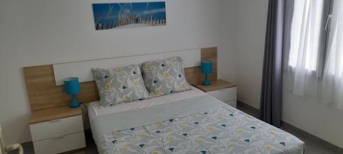 1 cama en un dormitorio con 2 jarrones azules en Maison T2 avec terrasse 700m de l'océan aux BOUCHOLEURS- En été location vendredi à vendredi en Yves