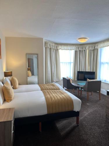 a hotel room with a large bed and a desk at Clifton Hotel in Scarborough