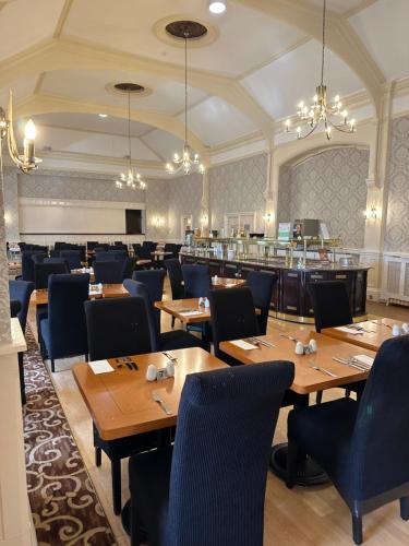a dining room with wooden tables and chairs at Clifton Hotel in Scarborough