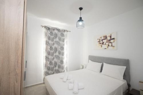 een slaapkamer met een wit bed en een raam bij Island Dreaming Opal 2 Bd in Mykonos with shared pool in Plintri