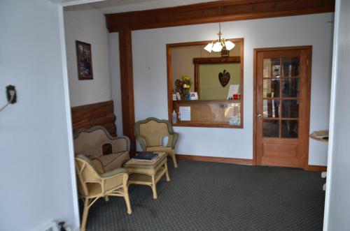 a room with two chairs and a table and a mirror at Aquarius Motel in Perth