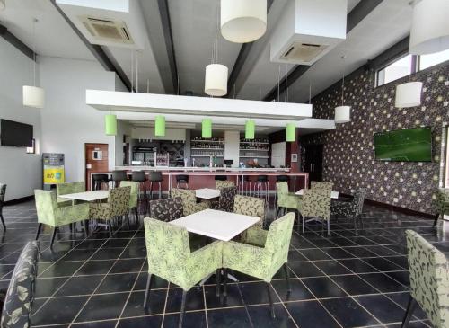 a restaurant with tables and chairs and a bar at Rosseta’s Golf Retreat in Roodepoort