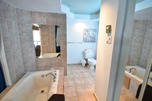 y baño con bañera, aseo y lavamanos. en Le Petit Loft du boisé - Nature et ski en Saint-Donat-de-Montcalm