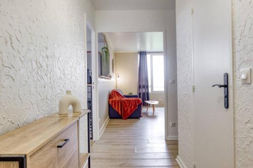 een woonkamer met een tafel en een rode stoel bij Cocon Parisien in Ris-Orangis