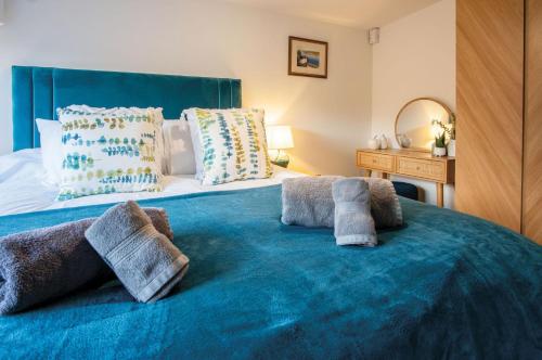 a bedroom with a blue bed with towels on it at Anchor Well - 2 Bedroom Cottage - Ludchurch in Ludchurch