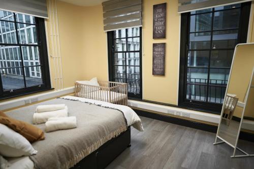 - une chambre avec des fenêtres et un lit avec des serviettes dans l'établissement Charming 1BR Flat in the Heart of City of London, à Londres
