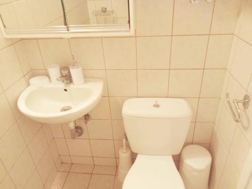 a small bathroom with a toilet and a sink at Happiness House in Kallithea Halkidikis