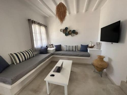 un soggiorno con divano e TV di Dreamy Island Escape in Naousa Paros a Naoussa