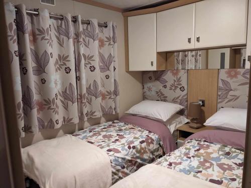 a small room with two beds and curtains at Foxgloves and Ivy in Cockermouth