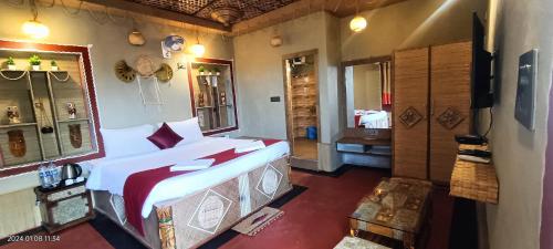 a bedroom with a large bed and a mirror at Gharana Resort in Singur