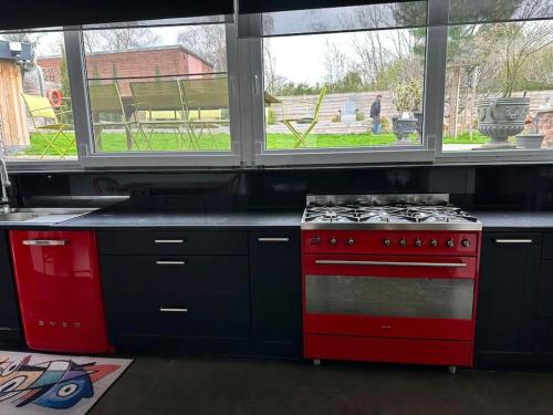 - une cuisine équipée de plaques de cuisson rouges et de fenêtres dans l'établissement Chez Tangs, à Liège