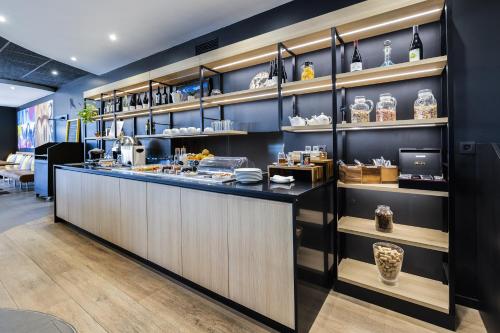 リヴサルトにあるCampanile Perpignan Nord - Aéroportの棚に料理が置かれたカウンターのあるレストラン