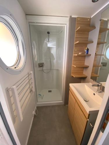 une salle de bain avec douche et lavabo dans l'établissement Camping Quiberon - Mobilhomes Bord de Mer, Conguel, à Quiberon