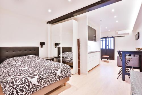 um quarto com uma cama em preto e branco e uma mesa em Blue Nights Apartments - Sébastopol em Paris