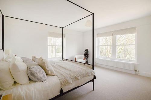 - une chambre avec un grand lit et un grand miroir dans l'établissement Trinity Farmhouse - Stunning House & Gardens!, à North Cerney