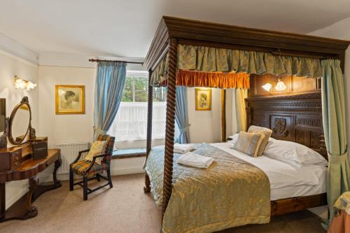 a bedroom with a canopy bed and a desk at Two Bridges Hotel in Two Bridges