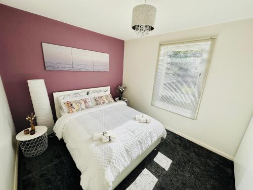 a bedroom with a white bed and a purple wall at Glasgow Modern style home , separate entrance in Knightswood
