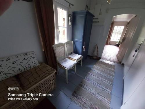 a living room with a couch and a chair and a window at Maison de charme à Annebault avec jardin clôt et barbecueA in Annebault