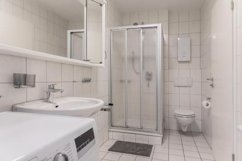 a bathroom with a shower and a sink and a toilet at 50180... in Harlesiel