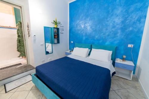 een blauwe slaapkamer met een bed en een blauwe muur bij B&b Anna's home in Marina di Camerota