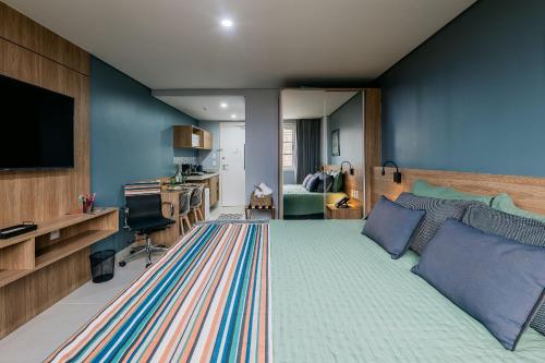 a bedroom with a large bed and a television at Studios Exclusivos Xavishome Granja Brasil Itaipava in Itaipava