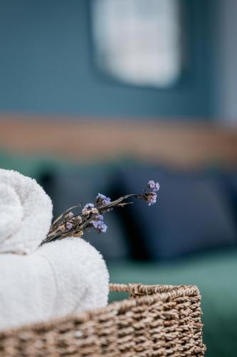 a bundle of towels with a flower in a basket at Studios Exclusivos Xavishome Granja Brasil Itaipava in Itaipava