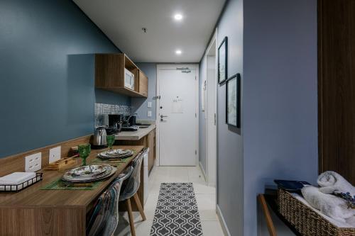 a kitchen with a table with plates on it at Studios Exclusivos Xavishome Granja Brasil Itaipava in Itaipava