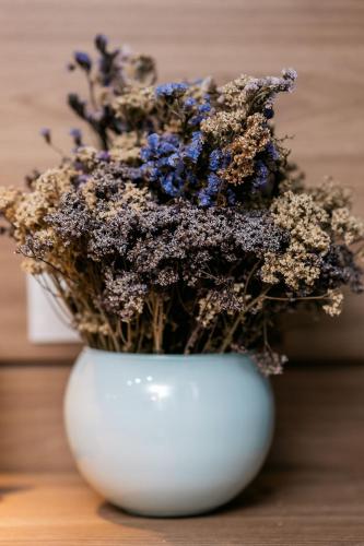 a white vase with blue flowers in it at Studios Exclusivos Xavishome Granja Brasil Itaipava in Itaipava