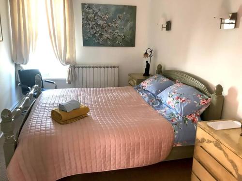 a bedroom with a bed with a pink blanket and pillows at Aule Apartment in Bembridge