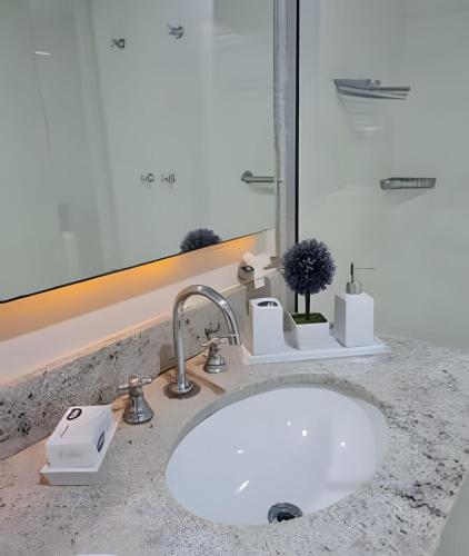 a sink in a bathroom with a mirror at Studios Exclusivos Xavishome Granja Brasil Itaipava in Itaipava