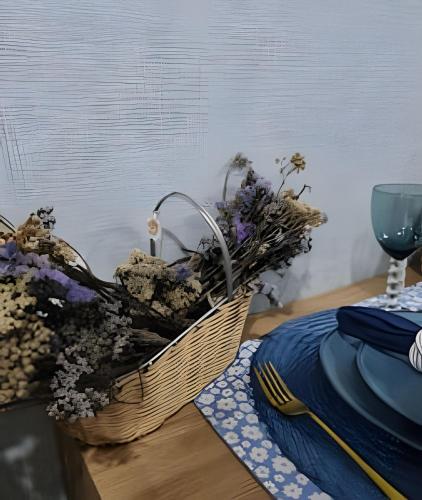 a basket of flowers sitting on a table with a glass at Studios Exclusivos Xavishome Granja Brasil Itaipava in Itaipava