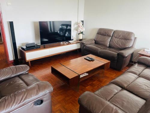 a living room with two couches and a television at Januario Maputo in Maputo