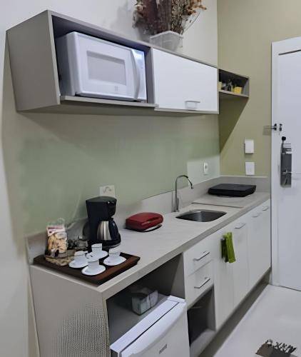 a kitchen with a sink and a microwave at Studios Exclusivos Xavishome Granja Brasil Itaipava in Itaipava