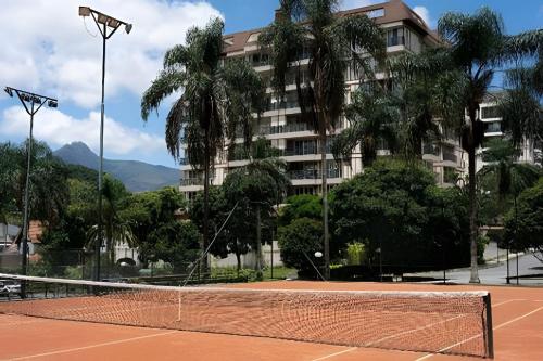 a tennis court in front of a building at Studios Exclusivos Xavishome Granja Brasil Itaipava in Itaipava