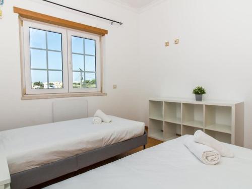 dwa łóżka w pokoju z oknem w obiekcie Balaia Mar House - Sea View & Playground & Garage & BBQ & Albufeira w Albufeirze
