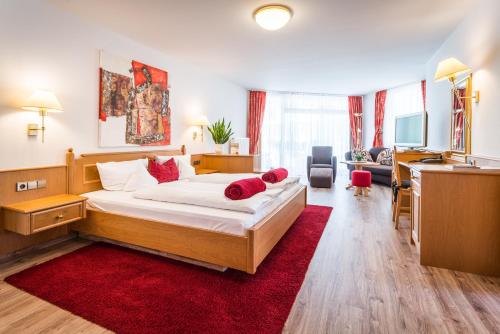 a hotel room with a large bed and a red rug at Naturparkhotel Adler in Wolfach