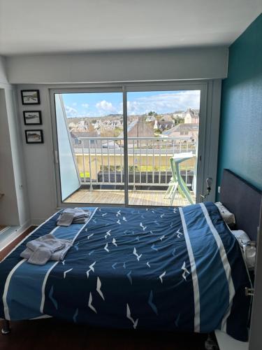 a bedroom with a bed and a large window at L'Imprenable vue mer in Crozon