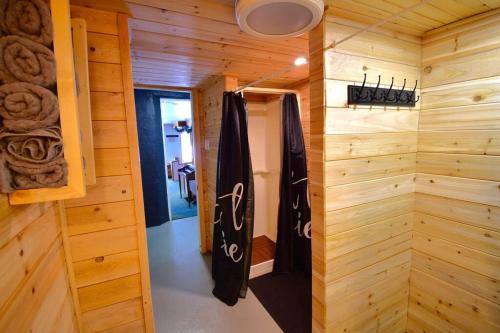 a room with a wooden wall with a door and a room with at Chalet de l'Auberge: Lac avec Plage, SPA & Billard in Saint-Donat-de-Montcalm