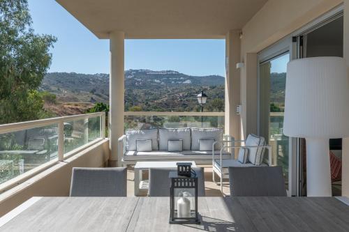 een woonkamer met een tafel en stoelen op een balkon bij Luxury & Comfort breathtaking views - La Cala Golf in Mijas
