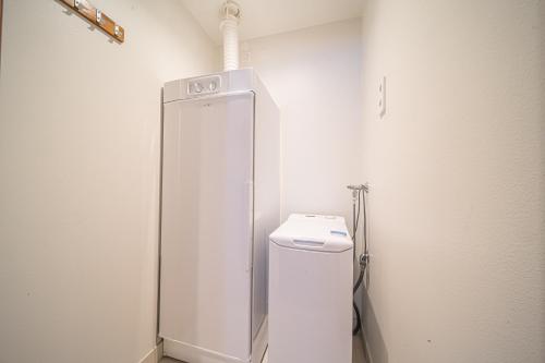 a white bathroom with a toilet and a shower at LEVI Tunturinlaita A4, Ski-in Ski-out 3xBedroom in Levi