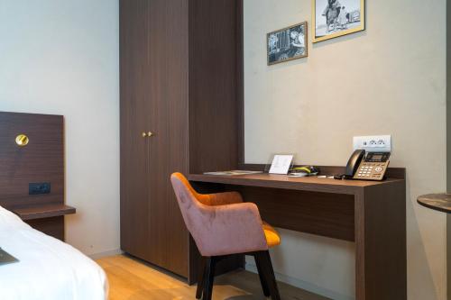 a hotel room with a desk with a phone at Business By Parkhotel -ANNEX- in Kortrijk