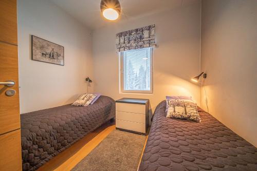 a bedroom with two beds and a window at LEVI Tunturinlaita A4, Ski-in Ski-out 3xBedroom in Levi