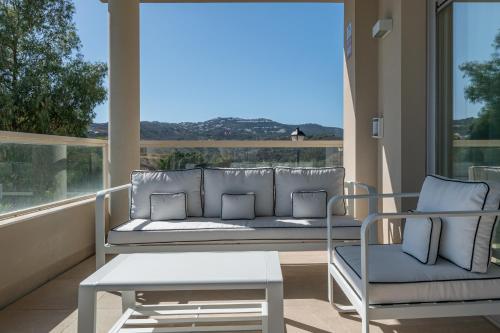 een veranda met een bank, 2 stoelen en een tafel bij Luxury & Comfort breathtaking views - La Cala Golf in Mijas
