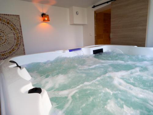 a bath tub filled with water in a bathroom at Appartement d'une chambre avec piscine partagee jacuzzi et jardin clos a Avignon in Avignon