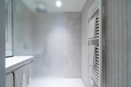 uma casa de banho branca com um lavatório e um frigorífico em Business By Parkhotel -ANNEX- em Kortrijk