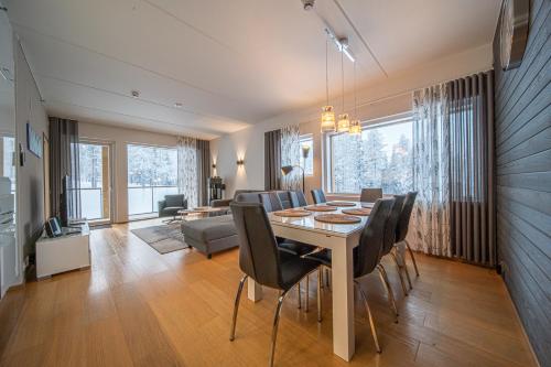 a dining room and living room with a table and chairs at LEVI Tunturinlaita A4, Ski-in Ski-out 3xBedroom in Levi