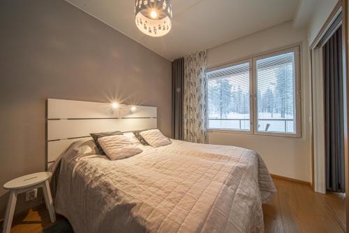 a bedroom with a bed and a large window at Tunturinlaita A4, Ski-in Ski-out 3xbedroom Levi in Kittilä